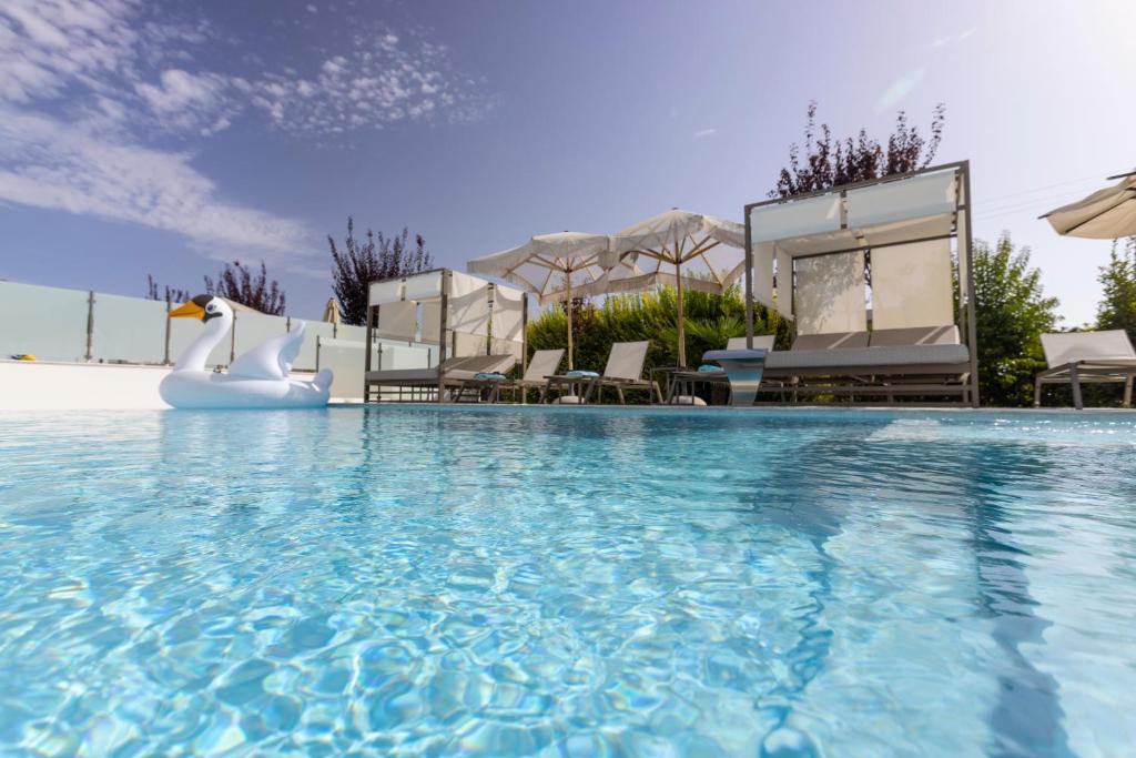 a swimming pool with chairs and an inflatable pool slide at White Pearl in Pefkochori