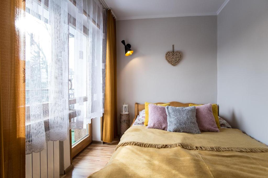 a bedroom with a bed and a large window at Zakopane - Harenda 13e in Zakopane