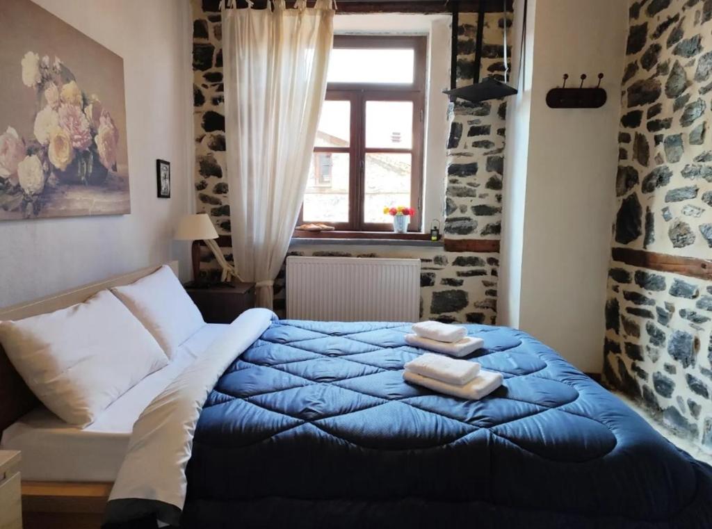 Un dormitorio con una cama azul con toallas. en Μaisonette Mary en Palaios Agios Athanasios