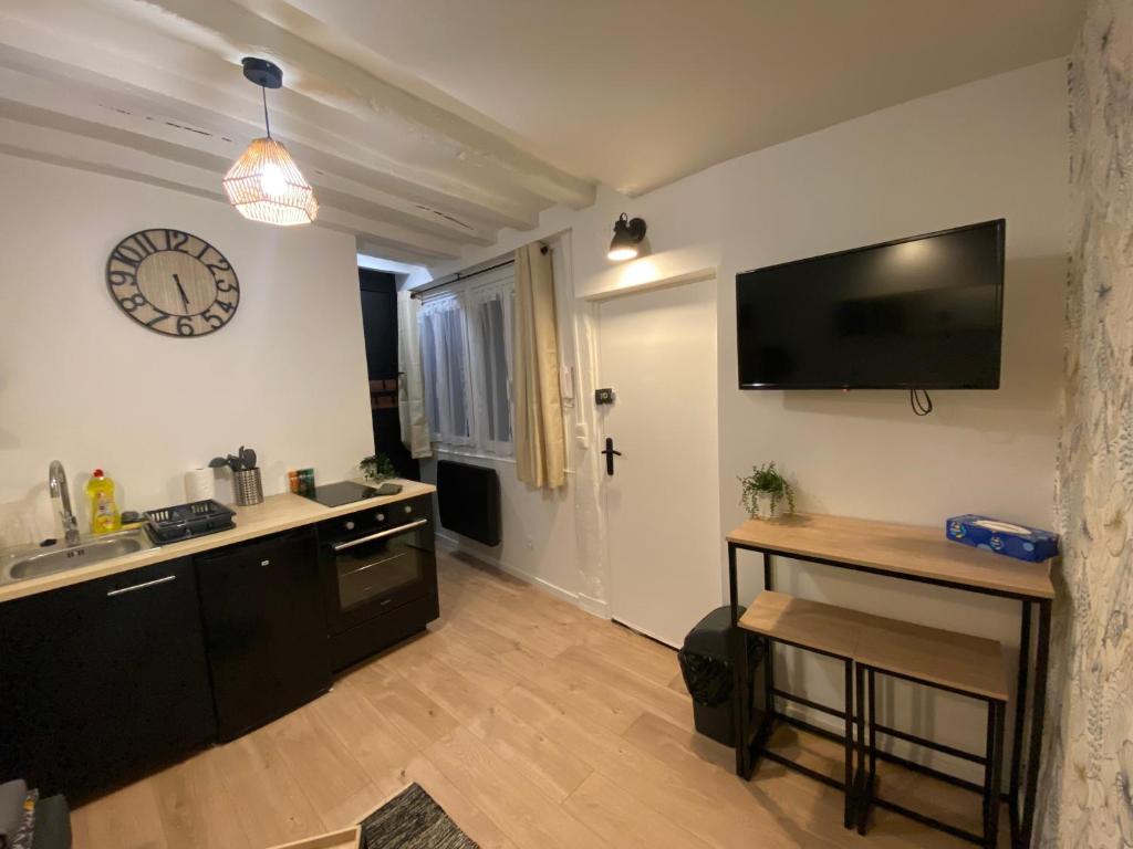 a kitchen with a sink and a clock on the wall at Studio entièrement refait a neuf - 170 in Rouen