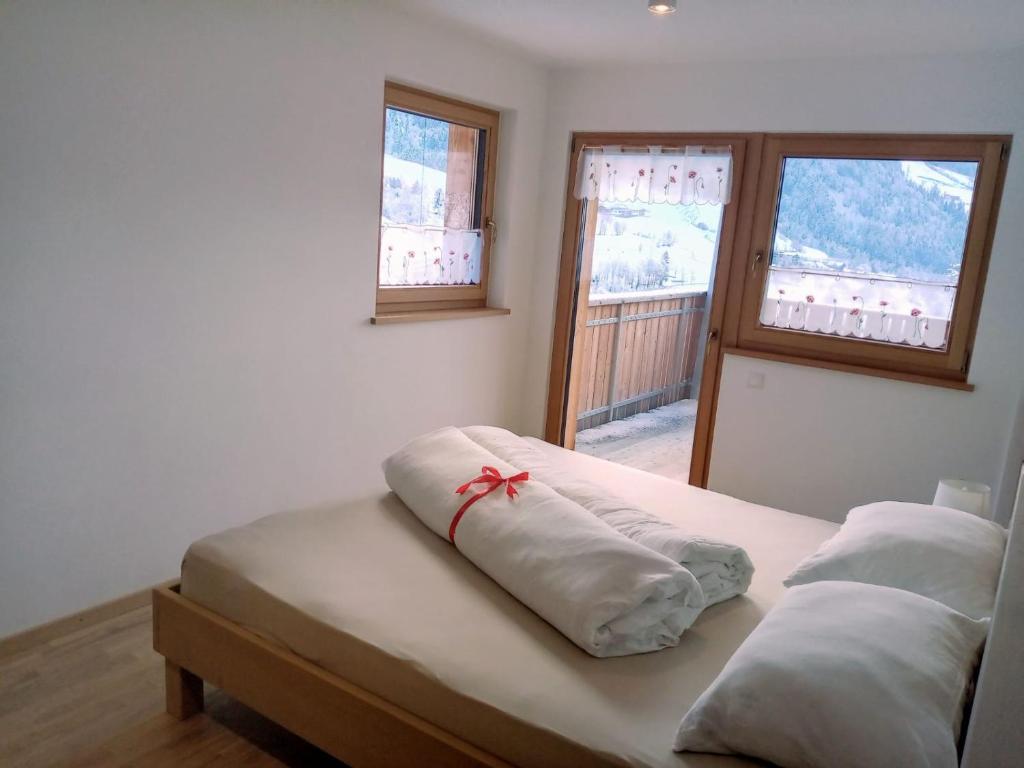 1 dormitorio con 2 almohadas en una cama y 2 ventanas en Obergereuth Hof, en San Martino