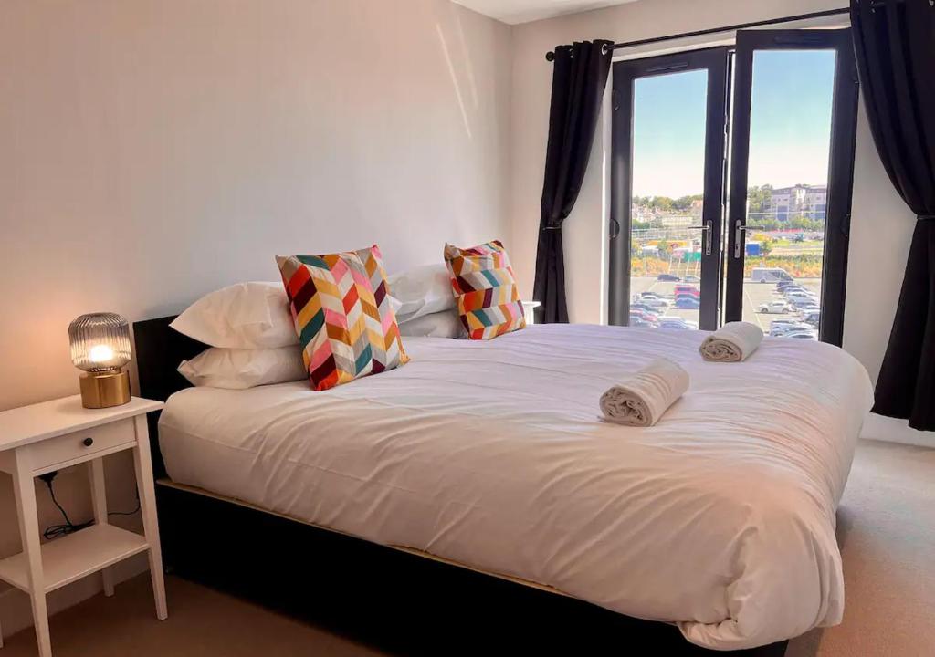 a bedroom with a large white bed with a window at Margate Seaside Penthouse With Sea views Sleeps 6 in Kent
