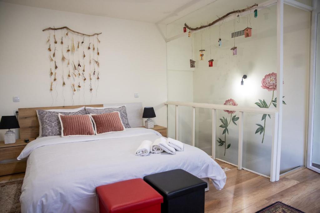 een slaapkamer met een wit bed en een rode kruk bij Maison d' Alice 1 in Tríkala