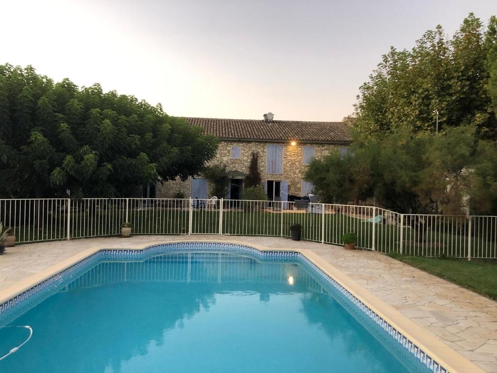 une piscine en face d'une clôture dans l'établissement Mas des Rompides, à Maillane