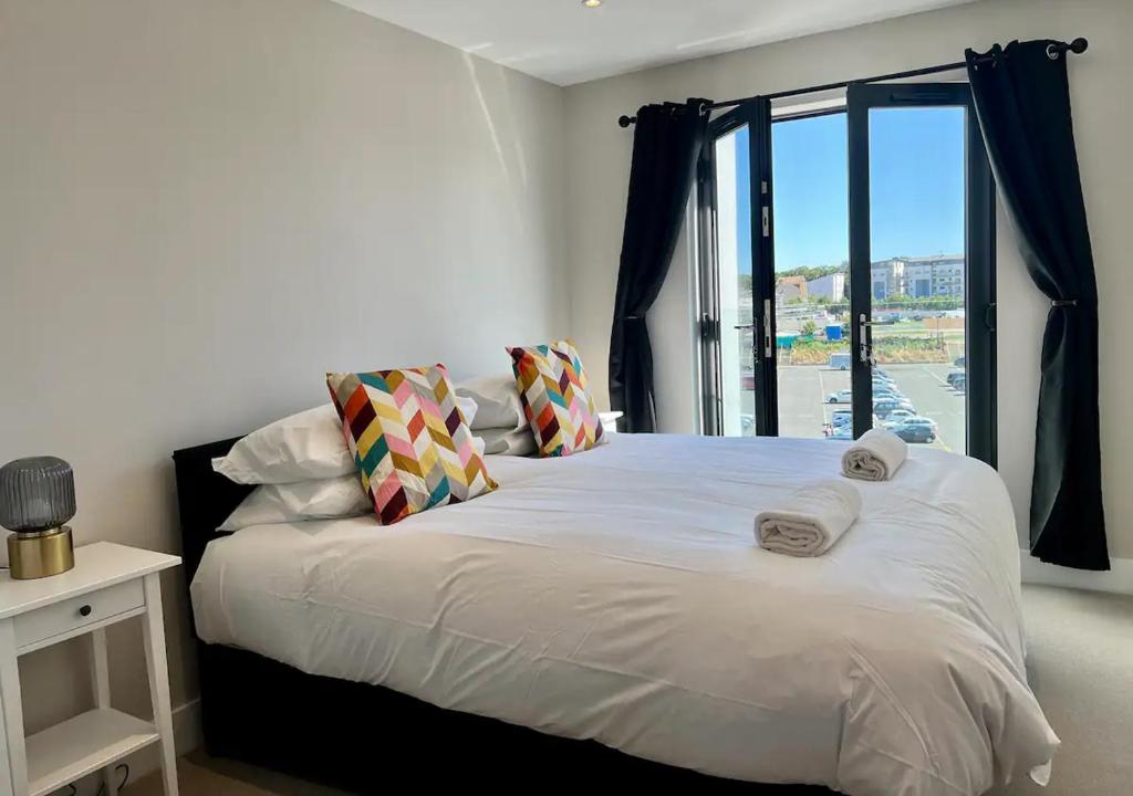 a bedroom with a large white bed with a window at Beachfront Bliss Margate With Sea Views Sleeps 7 in Kent