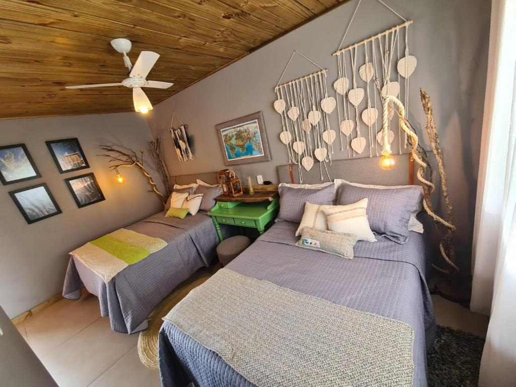 a room with three beds and a ceiling at Refúgio dos Coiotes in Cambará