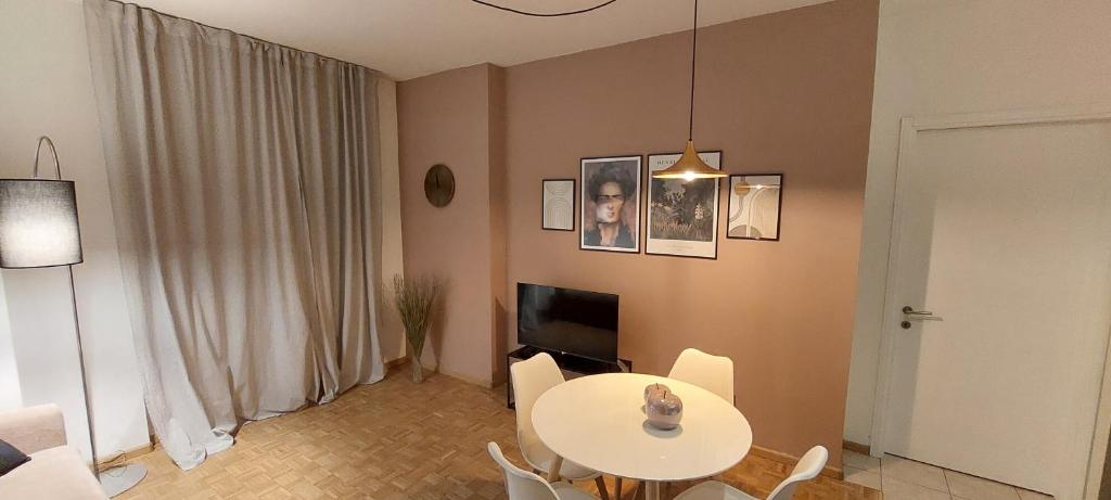 - un salon avec une table et des chaises blanches dans l'établissement Appartamento Perini, à Trente