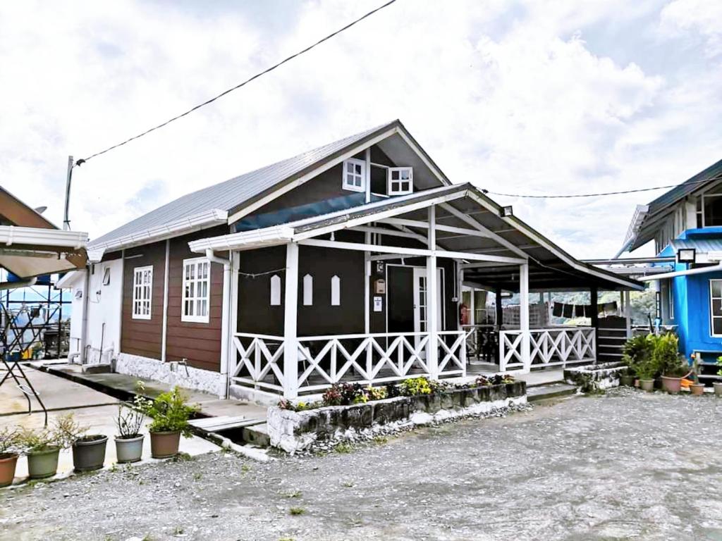 Dongorit Cabin House 1 في Kampong Kundassan: منزل أبيض وأسود مع شرفة