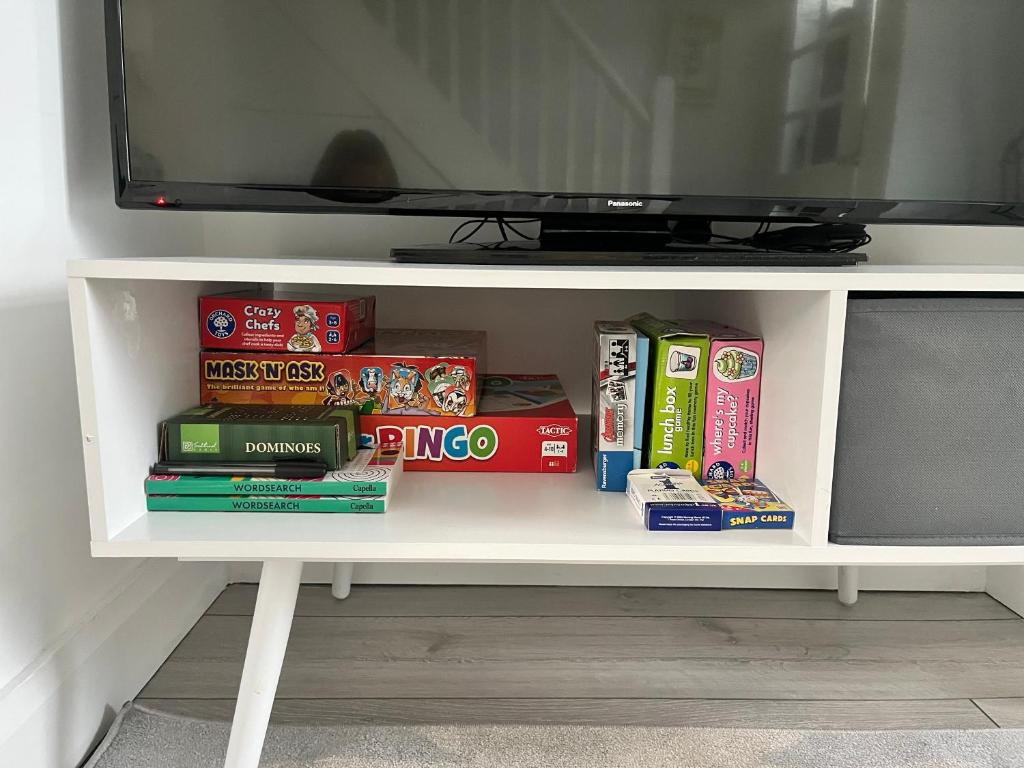 a white shelf with books and a television on it at Stay-K-Belfast Cosy Entire House 10 mins from City Centre in Belfast