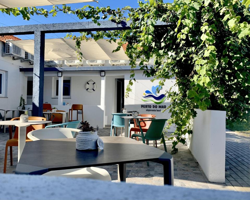 a group of tables and chairs in a patio at Perto do Mar, Alojamento Local in Gafanha da Boa Hora