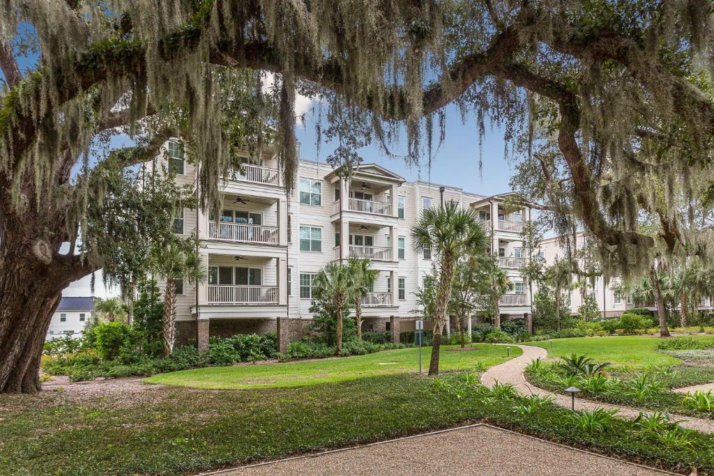 ein großes weißes Gebäude mit Bäumen davor in der Unterkunft The Villas at Gascoigne - 117 Gascoigne Ave, #305 in Saint Simon Mills