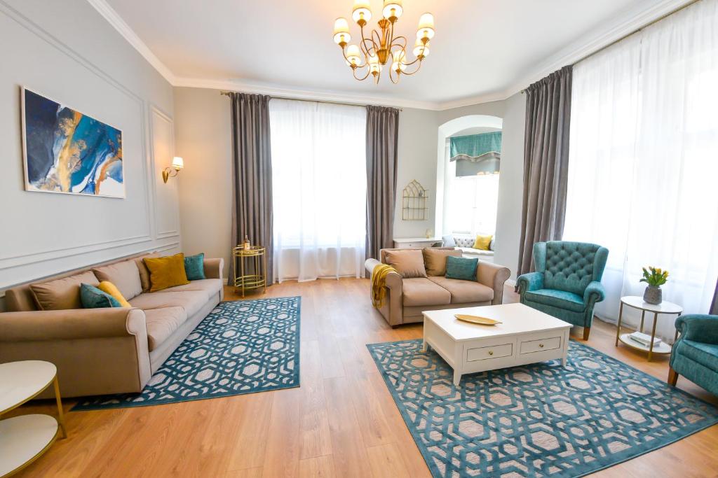 a living room with a couch and chairs and a table at Victoria's Old Town Deluxe Apartment in Timişoara