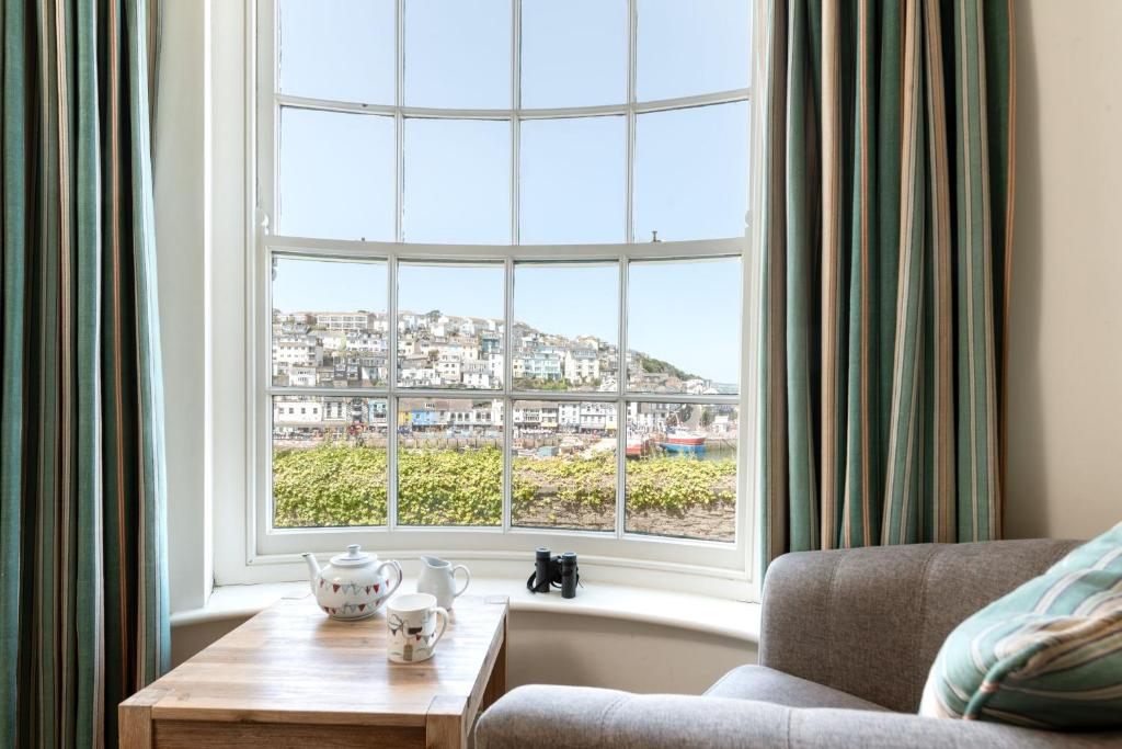 a living room with a large window and a couch at Coral in Brixham