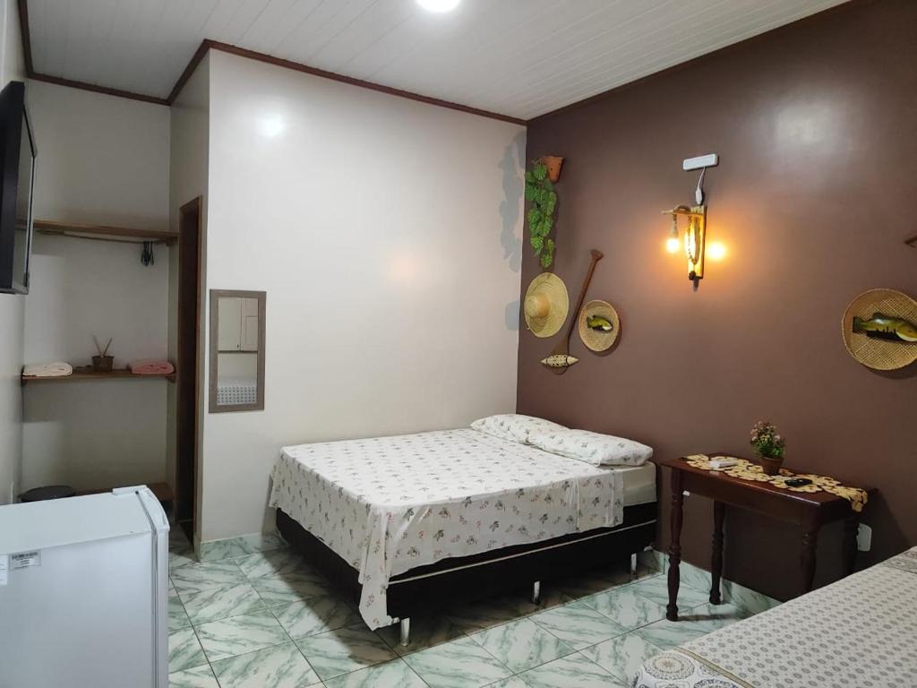 Pousada Vipayu perto da Orla de Alter a apenas 50 metros da praia في ألتر دو تشاو: غرفة نوم صغيرة مع سرير وطاولة