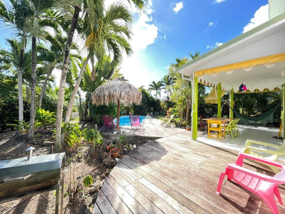 a wooden deck with a pink bench on a house at Villa TrÔpik Diamond + Bungalow in Le Diamant