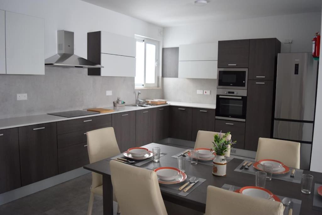 uma cozinha com uma mesa e cadeiras numa cozinha em Lovely 3-bedroom apartment in L-Iklin em Iklin
