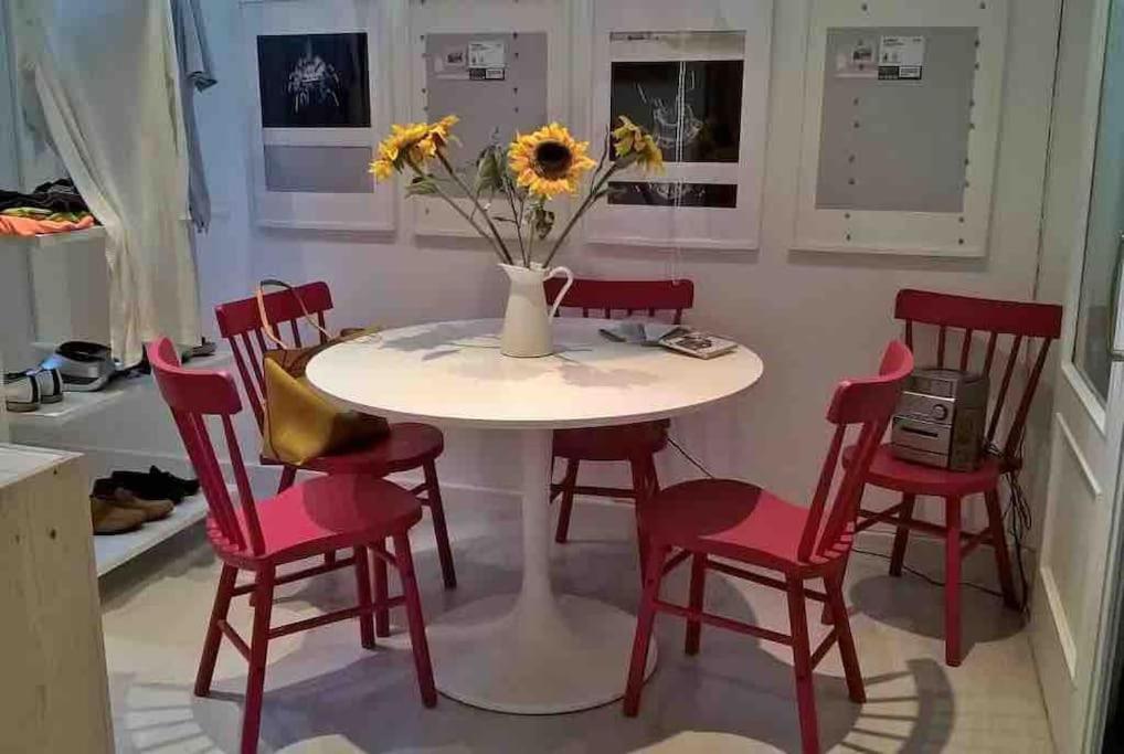 una mesa de cocina con sillas rojas y un jarrón con flores en Alojamiento privado en casa de montaña, en Matadepera