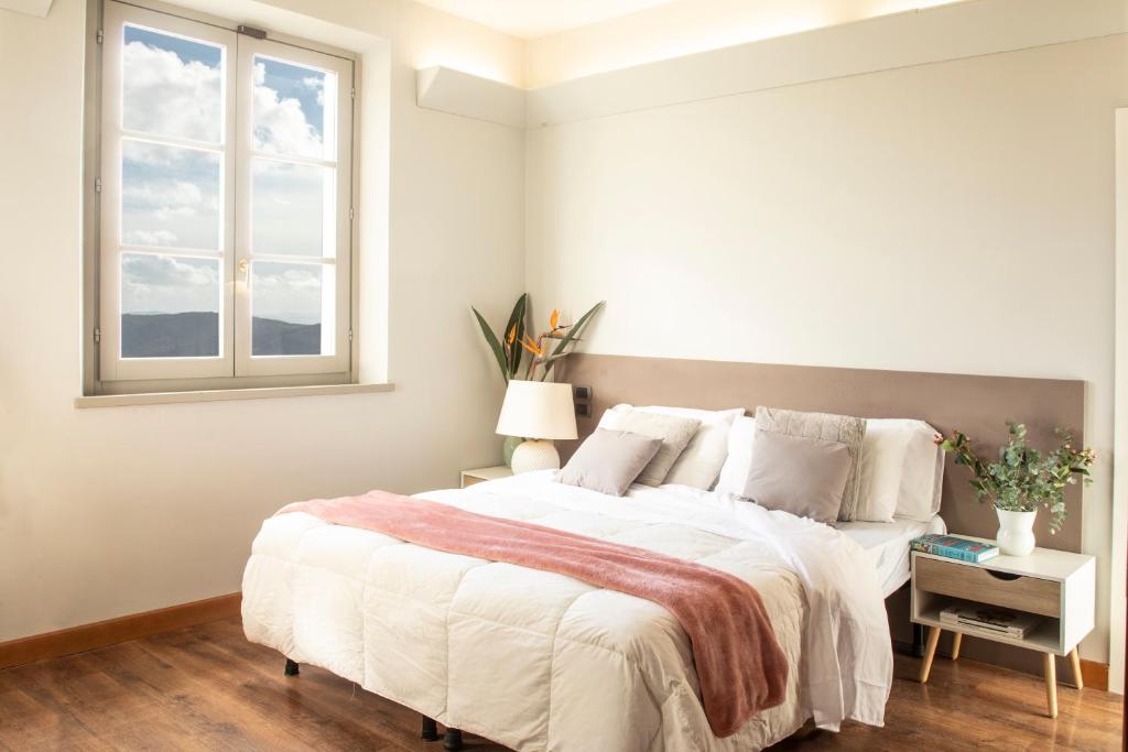 Un dormitorio con una cama grande y una ventana en Locanda agli Amici, en Cortona