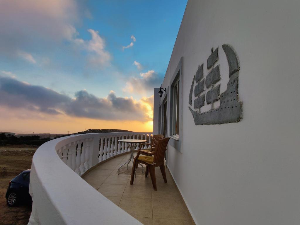 - Balcón con sillas y mesa en un edificio en Lakena Sunset View Villa, en Menetaí