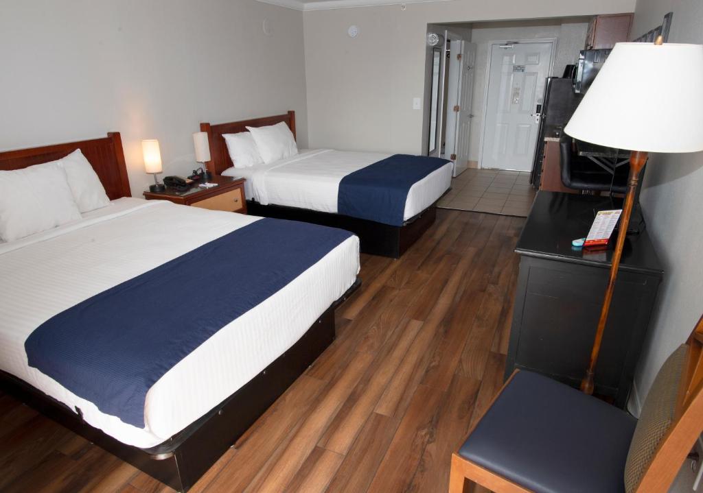 a hotel room with two beds and a lamp at Aqua Beach Inn in Myrtle Beach