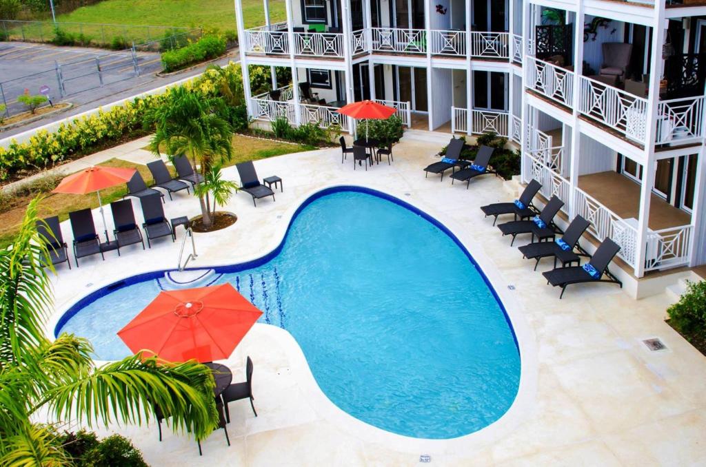 an overhead view of a swimming pool with chairs and umbrellas at Lantana Resort Barbados by Island Villas in Saint James