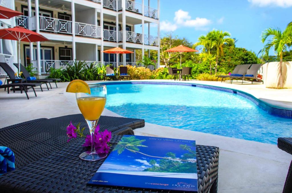 a drink on a table next to a swimming pool at Lantana Resort Barbados by Island Villas in Saint James