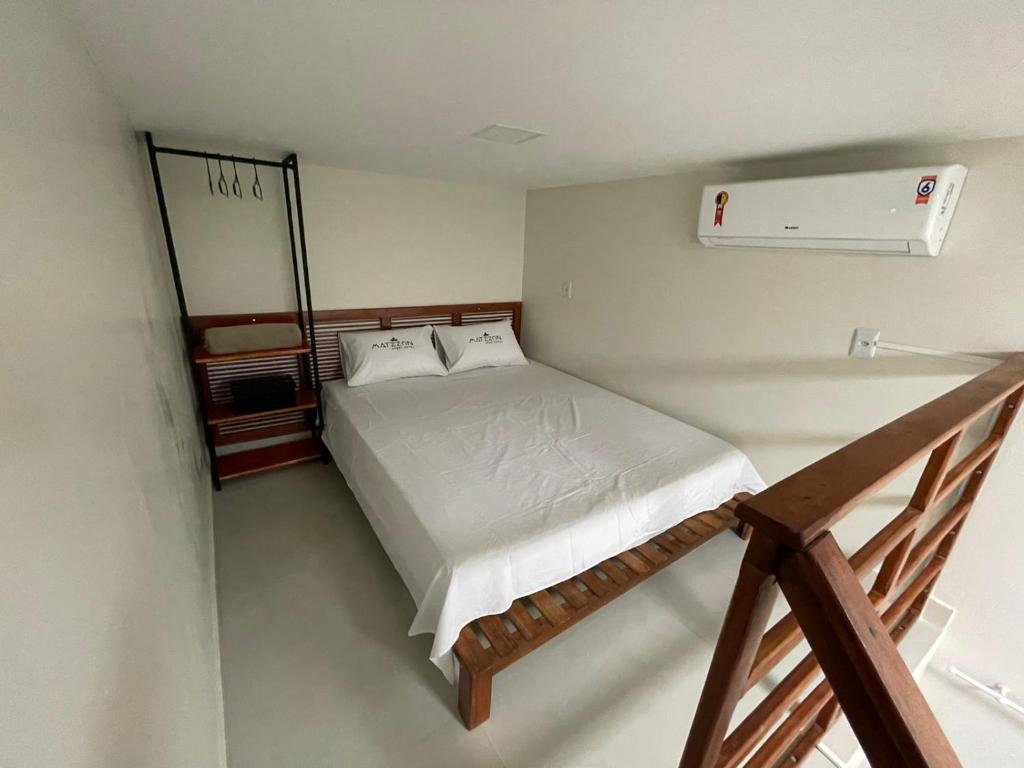 a small bedroom with a bed and a staircase at Matzzon Apart Hotel in João Câmara