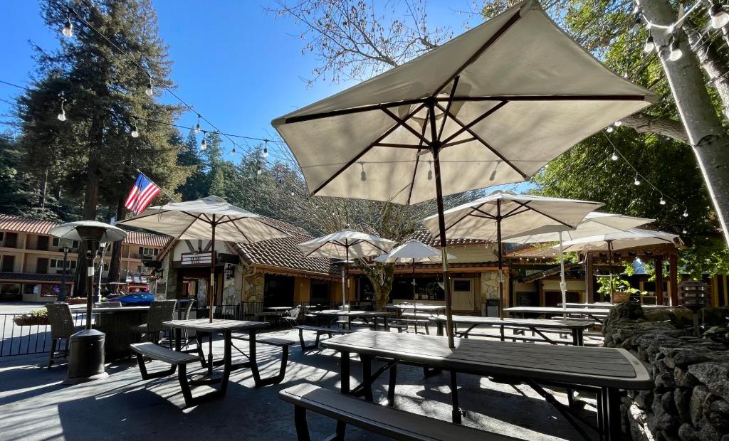 een groep tafels en stoelen met parasols bij The Historic Brookdale Lodge, Santa Cruz Mountains in Brookdale
