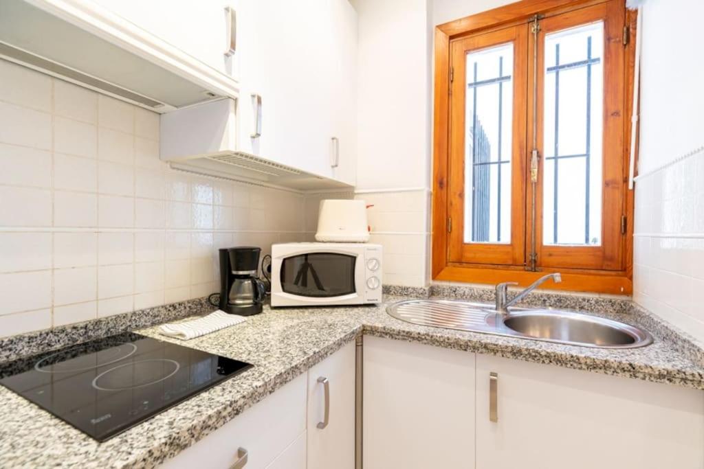 kuchnia ze zlewem i kuchenką mikrofalową w obiekcie AC Apartamento Familiar fantástica localizacion w Sewilli