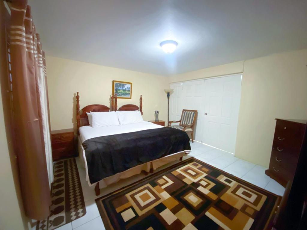 1 dormitorio con 1 cama grande y 1 alfombra en Russell Heights Vacation Home en Kingston