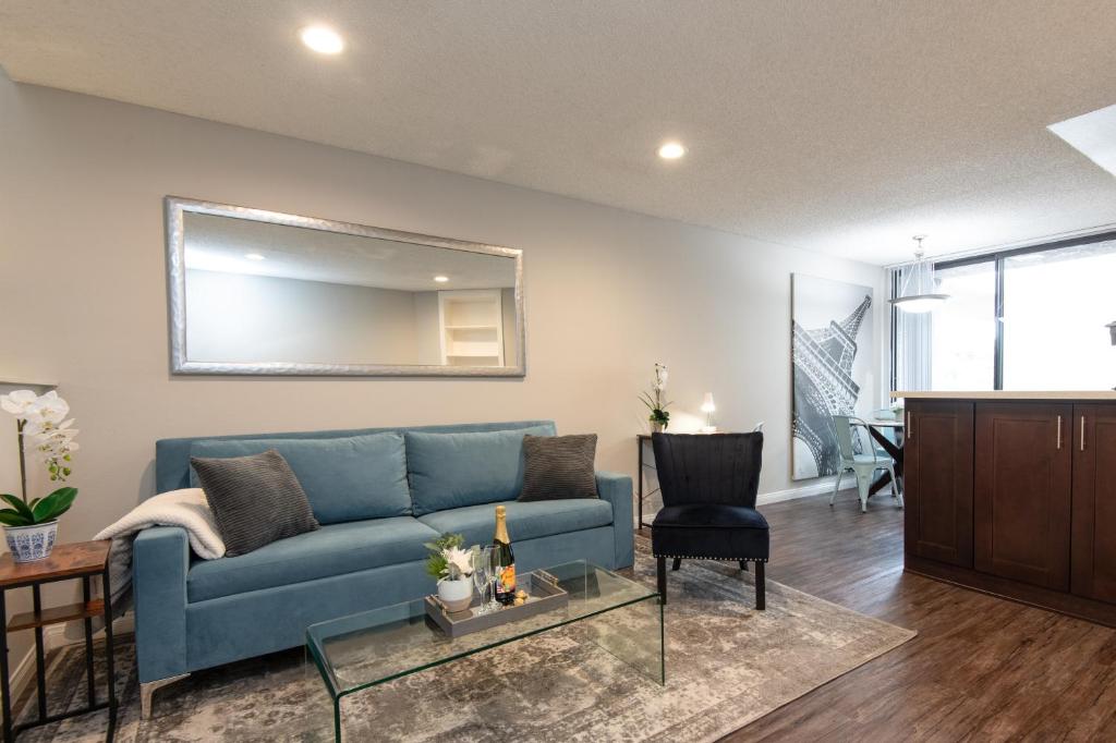 ein Wohnzimmer mit einem blauen Sofa und einem Spiegel in der Unterkunft Executive Studio Jr One Bedroom with Balcony and Pool in Los Angeles