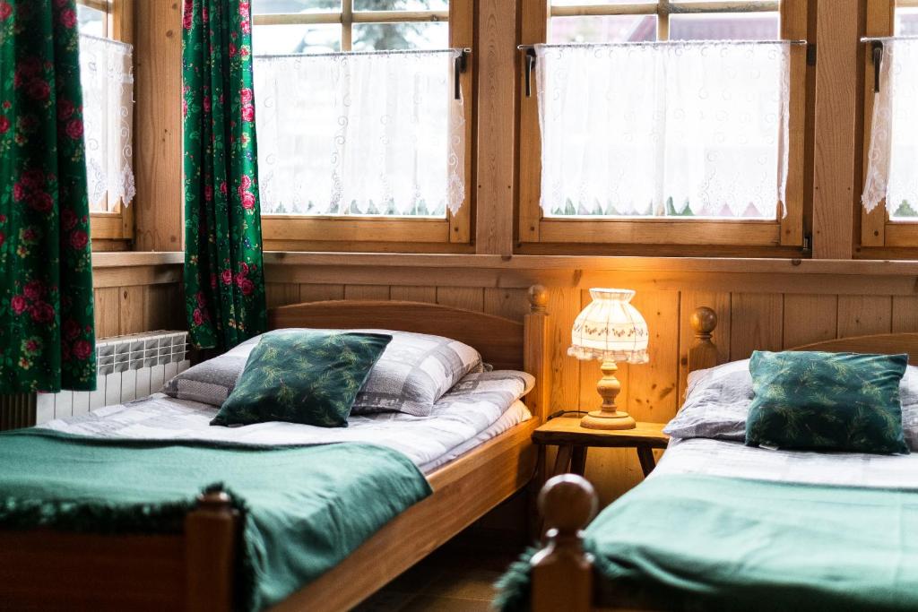 two twin beds in a room with windows at Zakopane - Króle 16 in Zakopane