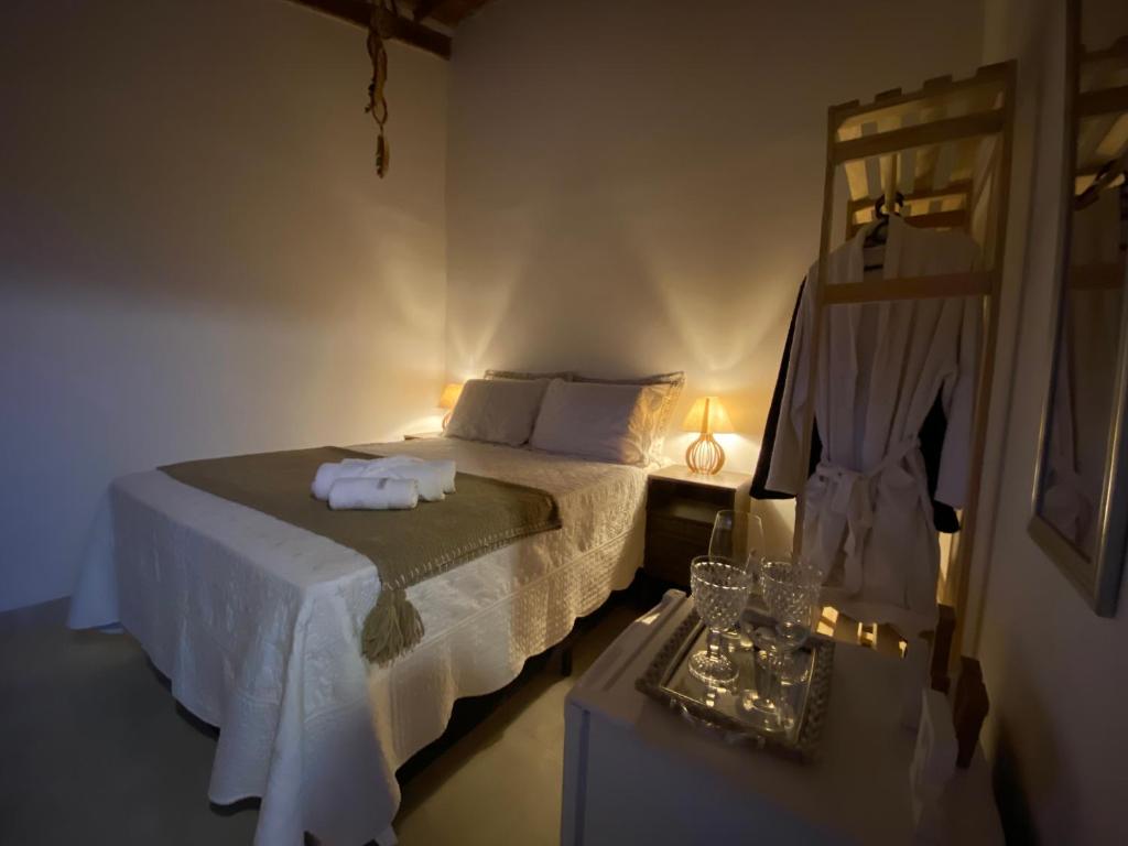 um quarto com uma cama e uma mesa com um espelho em Chalé Capão Vibes em Vale do Capão