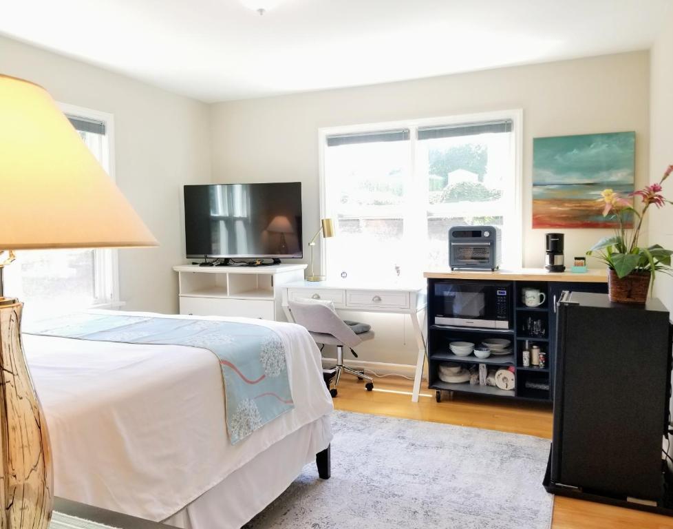 a bedroom with a bed and a desk and a tv at Cozy Relaxing Escape in Lakeridge