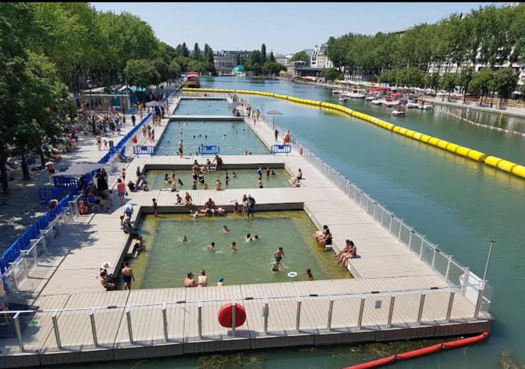 Un groupe de personnes dans un bassin dans une rivière dans l'établissement Agréable Appartement parking - quai de la seine, à Paris
