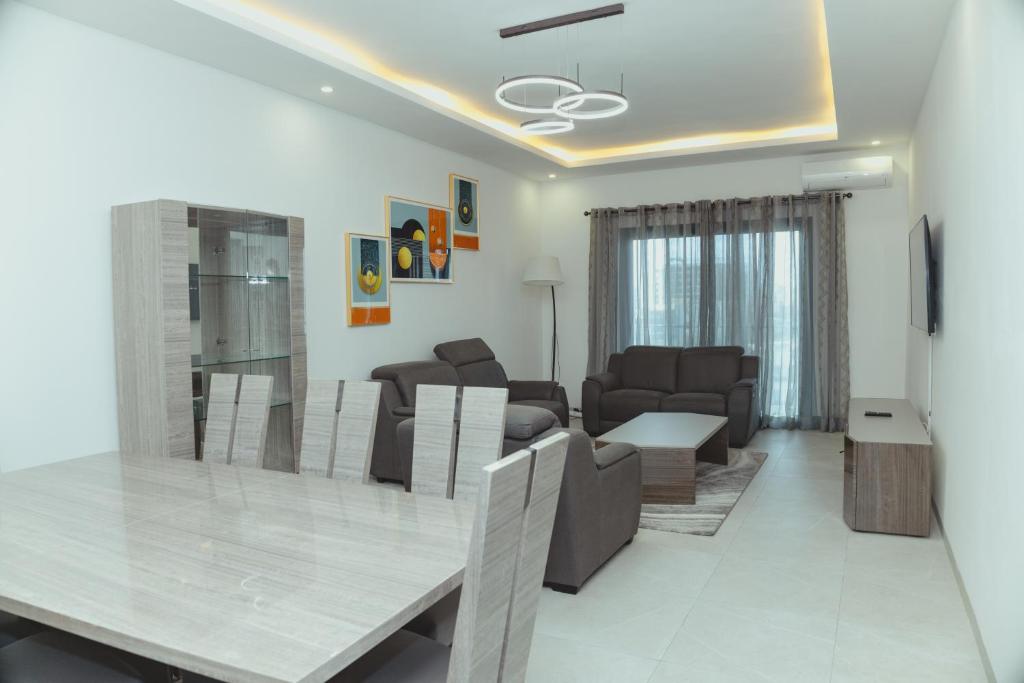 ein Esszimmer und ein Wohnzimmer mit einem Tisch und Stühlen in der Unterkunft Appartment Luxe CAPUCINE dans la Zone B Dakar in Fass