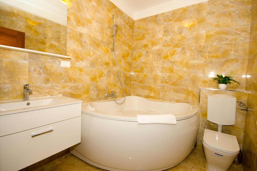 y baño con bañera, aseo y lavamanos. en Matić Guest House, en Dubrovnik