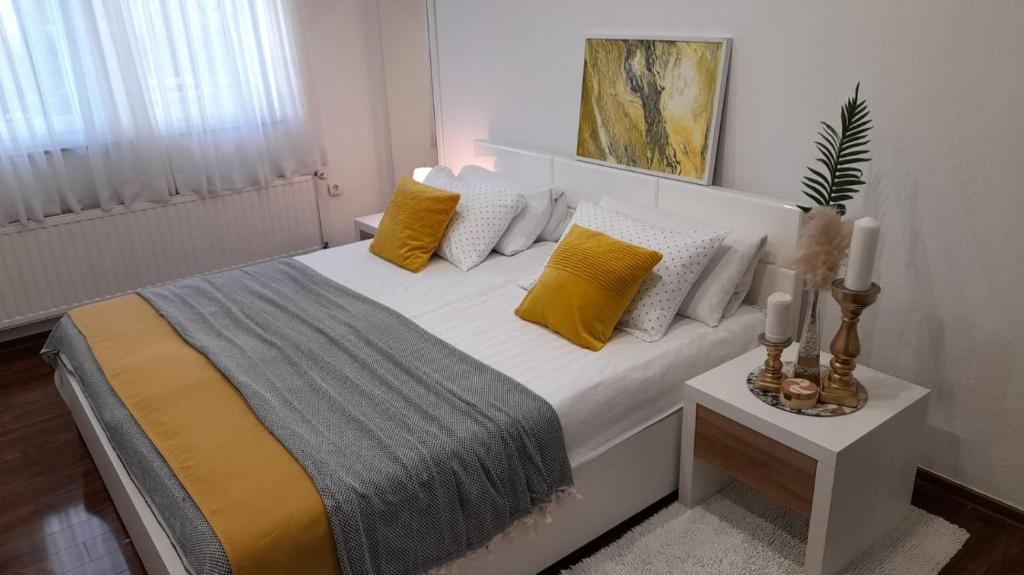 sypialnia z łóżkiem z żółtymi i białymi poduszkami w obiekcie Apartman Jasmina w mieście Bihać