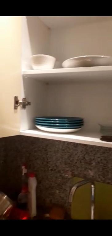 a kitchen with plates and bowls on a shelf at TABIB in Kenitra