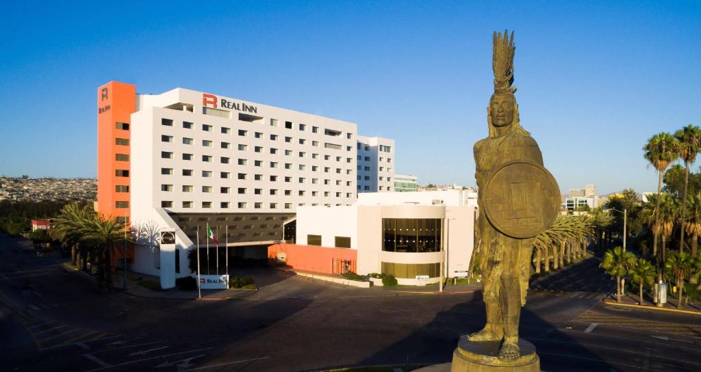 une statue d'une personne devant un bâtiment dans l'établissement Real Inn Tijuana by Camino Real Hoteles, à Tijuana