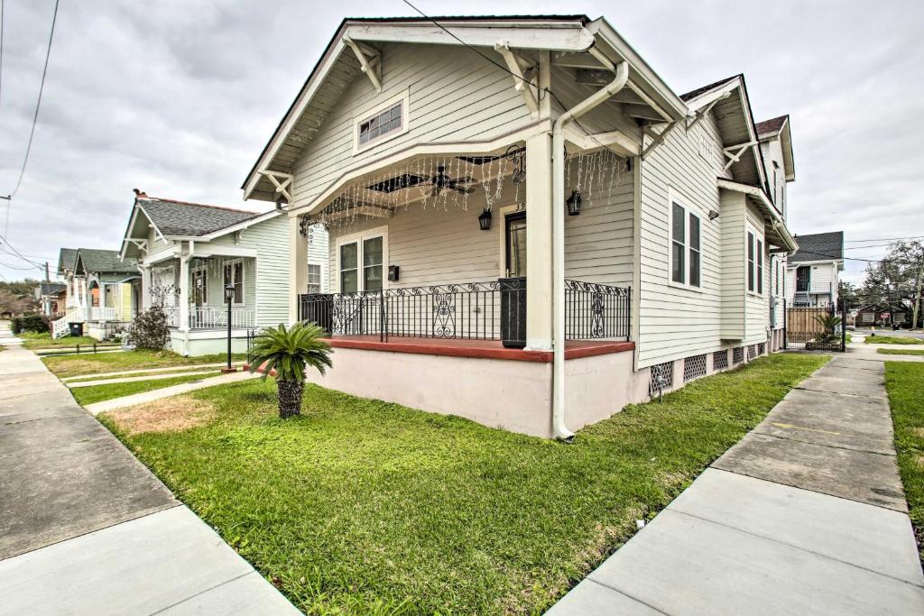 a white house with a porch and grass at Central New Orleans Apt with Updated Interior in New Orleans