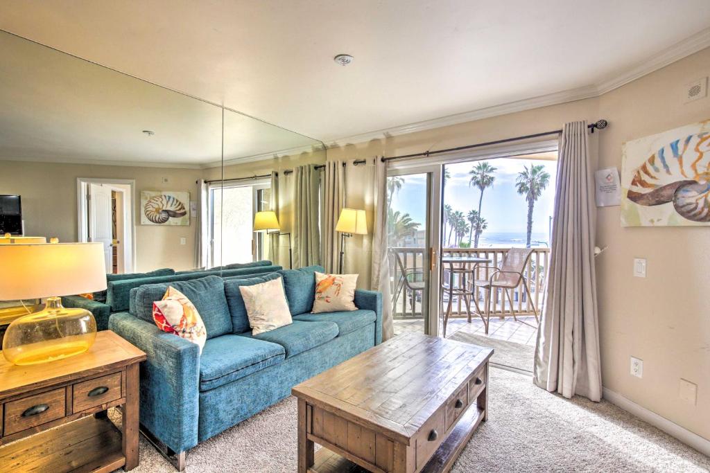 a living room with a blue couch and a table at Oceanfront Condo, Walk to Pacific Beach! in San Diego