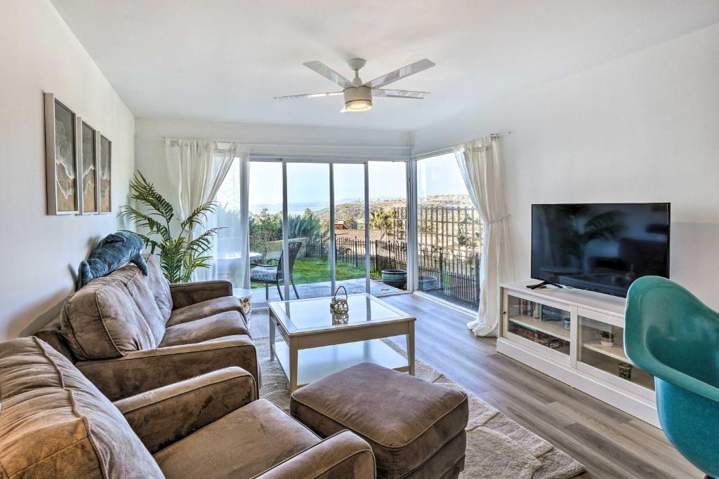 a living room with a couch and a flat screen tv at San Clemente Condo with Gorgeous Views Near Beach! in San Clemente