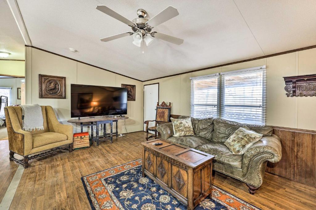 a living room with a couch and a tv at Ozark Mountain Cabin Rental on 300-Acre Ranch in Ozark