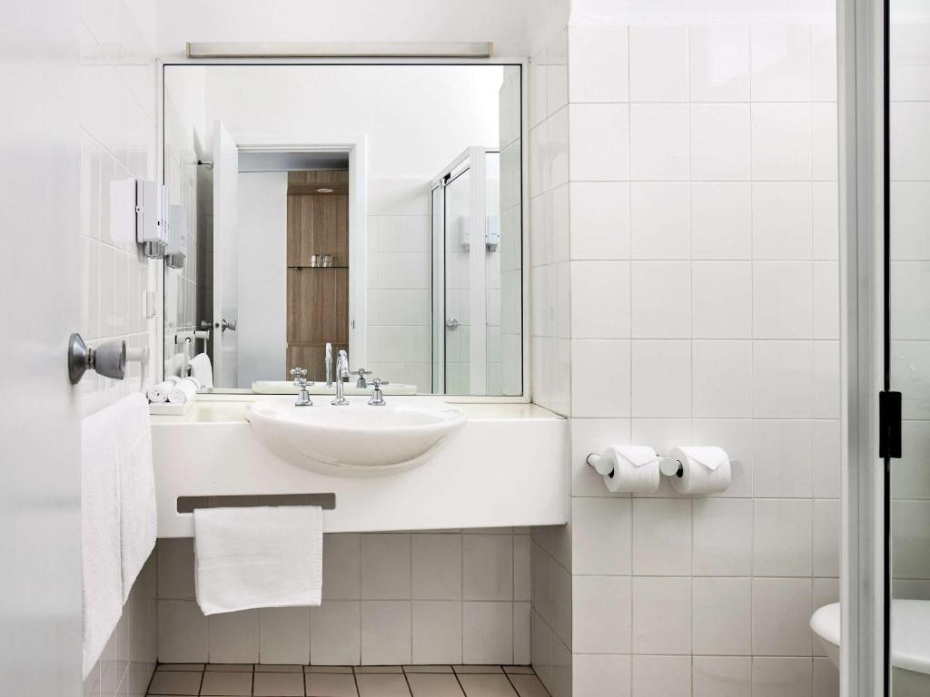 a white bathroom with a sink and a mirror at ibis Styles Tamworth in Tamworth