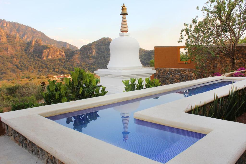 aiterende tempel naast een zwembad met uitzicht op de bergen bij Hostal de la Luz - Spa Holistic Resort in Tepoztlán