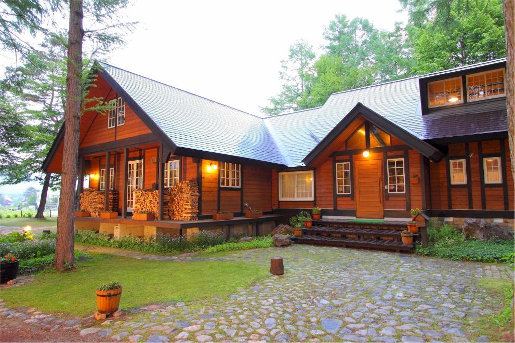 a large wooden house with a gambrel roof at Pension Ringo-no Ki in Hakuba