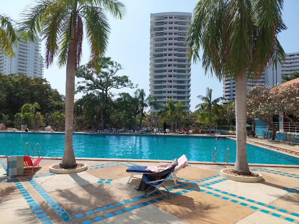 basen z palmami i krzesłem obok niego w obiekcie Viewtalay condo 5 D w Pattaya South