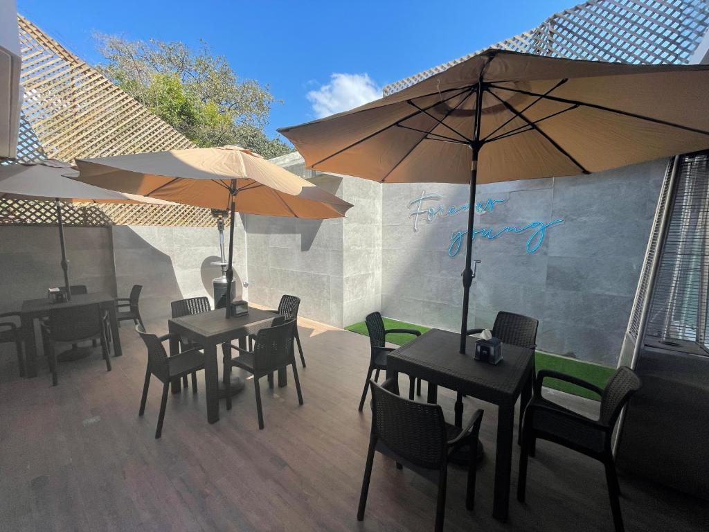 two tables and chairs with umbrellas on a patio at Hotel Villas Santander in Guatemala