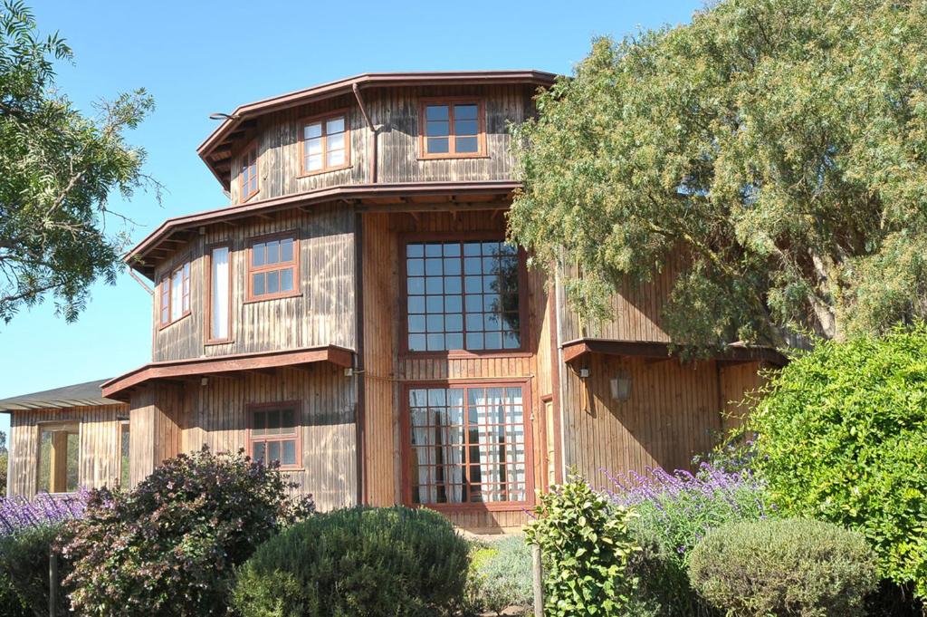 a large wooden house with a tree at B&B Casa Redonda in Santo Domingo